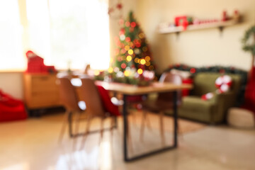 Blurred view of dining room with table, sofa and Christmas tree