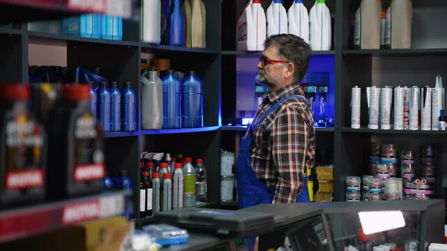 Senior Auto Parts Seller Selecting Oil for Customer