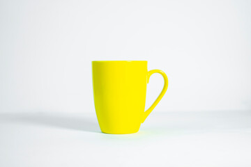 Minimalist Yellow Tea Cup with Handle on Clean White Surface