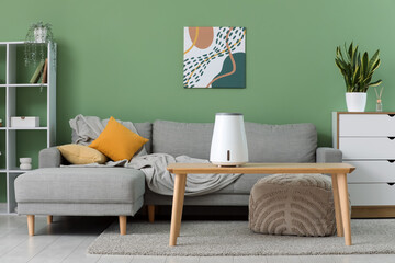 Interior of living room with sofa and air humidifier on table