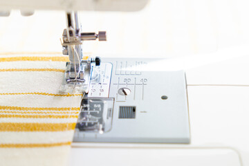 sewing machine with a cloth under a steel needle. manufacture of clothing. a household or industrial sewing machine. tailor, couturier. work on sewing designer clothes.