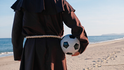 A Christian Priest Ready To Play with a soccer ball 