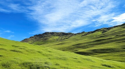 Naklejka premium Lush green hills under a vibrant blue sky