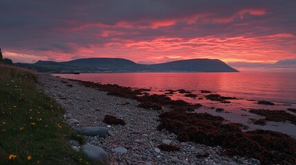 Coastal sunset, vibrant colors over ocean.  Rocky beach, dramatic sky