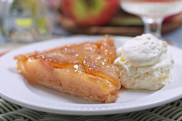 Apple tarte tatin with scoop of whipped cream, french upside down cake, horizontal closeup