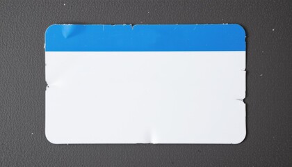 Blank name tag on a textured surface with a blue top stripe.