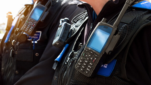 Police officers &ndash; Close-up of station police officers stab proof vest uniform worn by a couple of department cops at the scene of an incident. Officers enforce the law and protect the public.