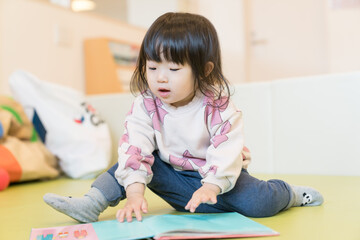 Naklejka premium 絵本を読む日本人の女の子