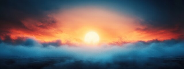 Fototapeta premium Bright sun sunrise over a layer of blue fog with dramatic orange and red clouds in the sky
