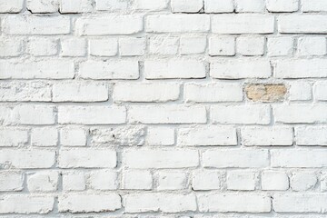 White painted brick wall with textured surfaces and slight weathering showing a single exposed section of original brick