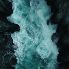 Powerful turquoise waterfall cascading over dark rocks.  Whirlpools and frothy water currents.  Dramatic natural beauty
