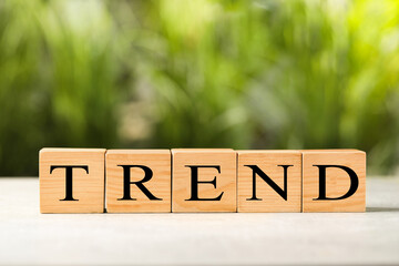 Word Trend made of wooden cubes with letters on table outdoors