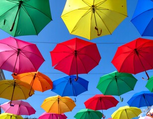 Obraz premium Colorful umbrellas hanging against a bright blue sky. A cheerful and vibrant scene.
