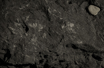 Dark jagged rock surface with natural patterns and textures
