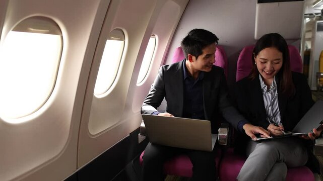 businessman and his secretary discuss sales paper while traveling by plane to sign a contract with another company, during the business trop of the two businessmen they double-checked to be sure