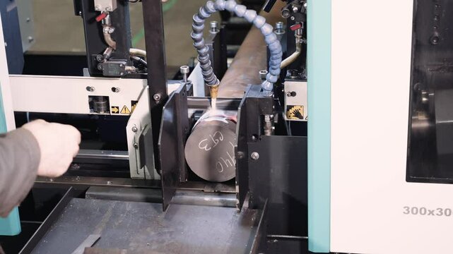 Band saw machine cuts metal detail under worker control