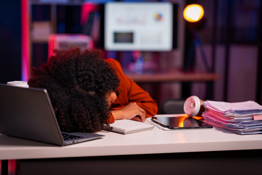 Tired businessman lying on the table after working for many hours, tired, falls asleep on the messy table Ready for a laptop after a long day at work?