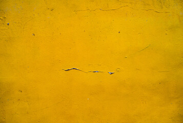 Pared amarilla con textura desgastada y grietas visibles en superficie de estuco - foto de stock