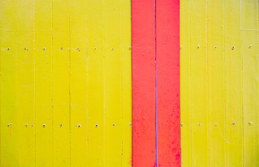 Pared de madera pintada con franjas verticales amarillas y rojas en estilo colorido y vibrante