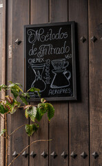 Cartel de Métodos de Filtrado de Café en Pizarra sobre Puerta de Madera con Planta de Café -...