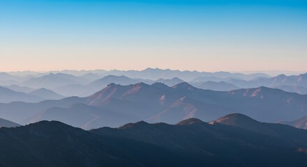 Panoramic View of Layered Mountains at Dawn with Soft Blue and Pink Hues in a Peaceful Landscape