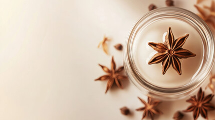 Star anise and clove spices with glass jar on soft neutral background, creating warm and natural feel for spice branding or culinary use