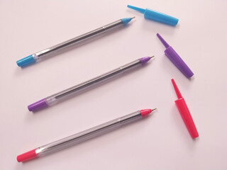 Colorful Ballpoint Pens with Open Caps on White Background