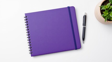 Vibrant Purple Notebook with Pen and Green Plant on White Background for Creative Workspace Inspiration