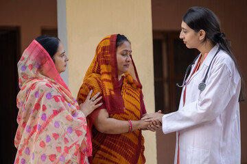 Concept of Indian rural women health in India. Indian female doctor standing with group of...