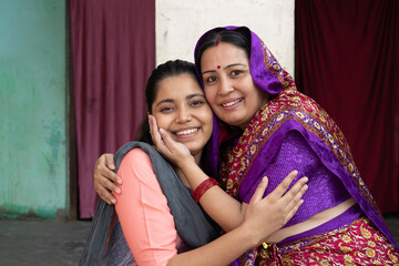 Indian happy rural mother embracing or hugging  to lovely daughter in home at village. Happy Mothers Day Concept. Mother and daughter Love bonding