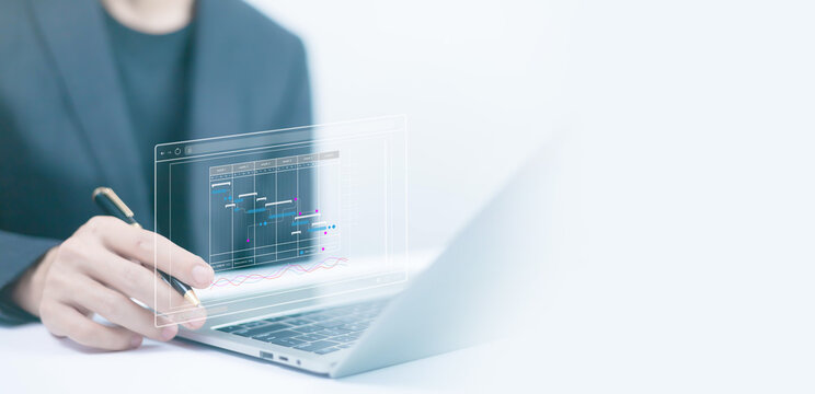 Businessman using laptop and phone to plan agenda and schedule appointment date time in meeting	
