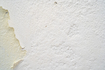 Close-up of textured white wall with peeling paint.