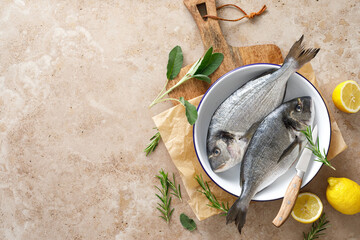 Fresh raw sea bream fish or dorado fish with lemon and herbs, top view