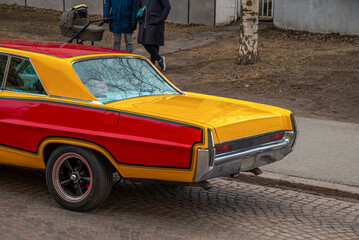 Retro car on a background of cobblestones. The back of the car. Side view.
