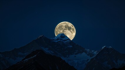 A full moon casts its soft moonlight across the dark mountain landscape under the vast night sky
