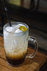 Pure coconut ice with brown sugar. A refreshing Indonesian drink. Coconut water drink in a glass with lime.