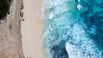 Top down Aerial view of beach with waves and blue water
