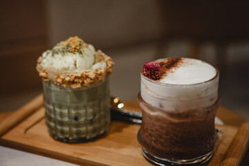 Matcha latte drink with vanilla ice cream and almond topping on wooden tray. Fresh cold drink.