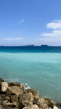 View of the Bay of Cannes with red rocks of Cap Esterel, Cannes, Cte d Azur, France. Cannes beach - France, Provence-Alpes-Cote d'Azur, View from beach to yachts in the evening. View of sea