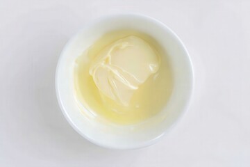 Raw egg white in ceramic bowl on white textured surface
