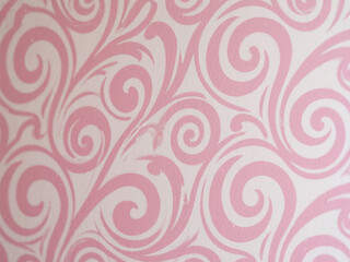 Fototapeta premium A pink wallpaper with a swirly design is clearly visible in a close-up, taking up most of the imag 