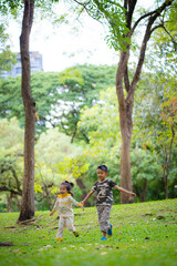 Fototapeta premium Adorable kid boy and girl enjoy run on greeen meadow grass city park