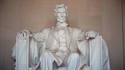 Imposing marble statue of President Abraham Lincoln sitting inside the Lincoln Memorial, a neoclassical monument honoring the 16th president of the United States