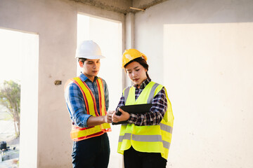 Engineers and architects collaborate at a construction site, wearing safety gear, examining blueprints, discussing plans, ensuring teamwork, development, and safety.