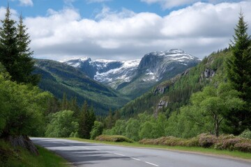 Fototapeta premium Scenic Mountain Road: Verdant Valley, Snow-Capped Peaks, Tranquil Landscape