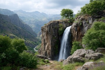 Obraz premium Majestic Waterfall Cascading in Mountain Valley: Serene Landscape Photography