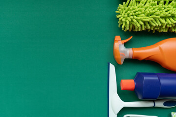 House cleaning plastic product on green table background, home service or housekeeping concept