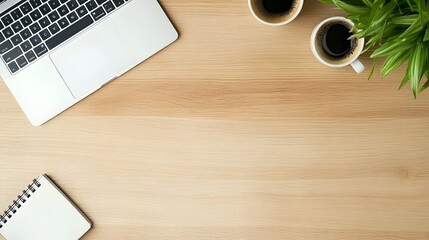 Top view of modern wooden workspace with laptop, coffee, notebook, and plants.


