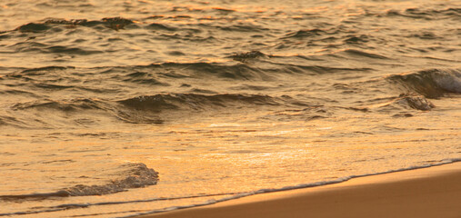 The ocean is calm and the sun is setting, creating a beautiful