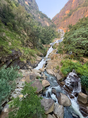 A waterfall is flowing down a rocky hillside